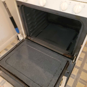 Open toaster oven with metal baking tray visible, interior and control panel exposed.